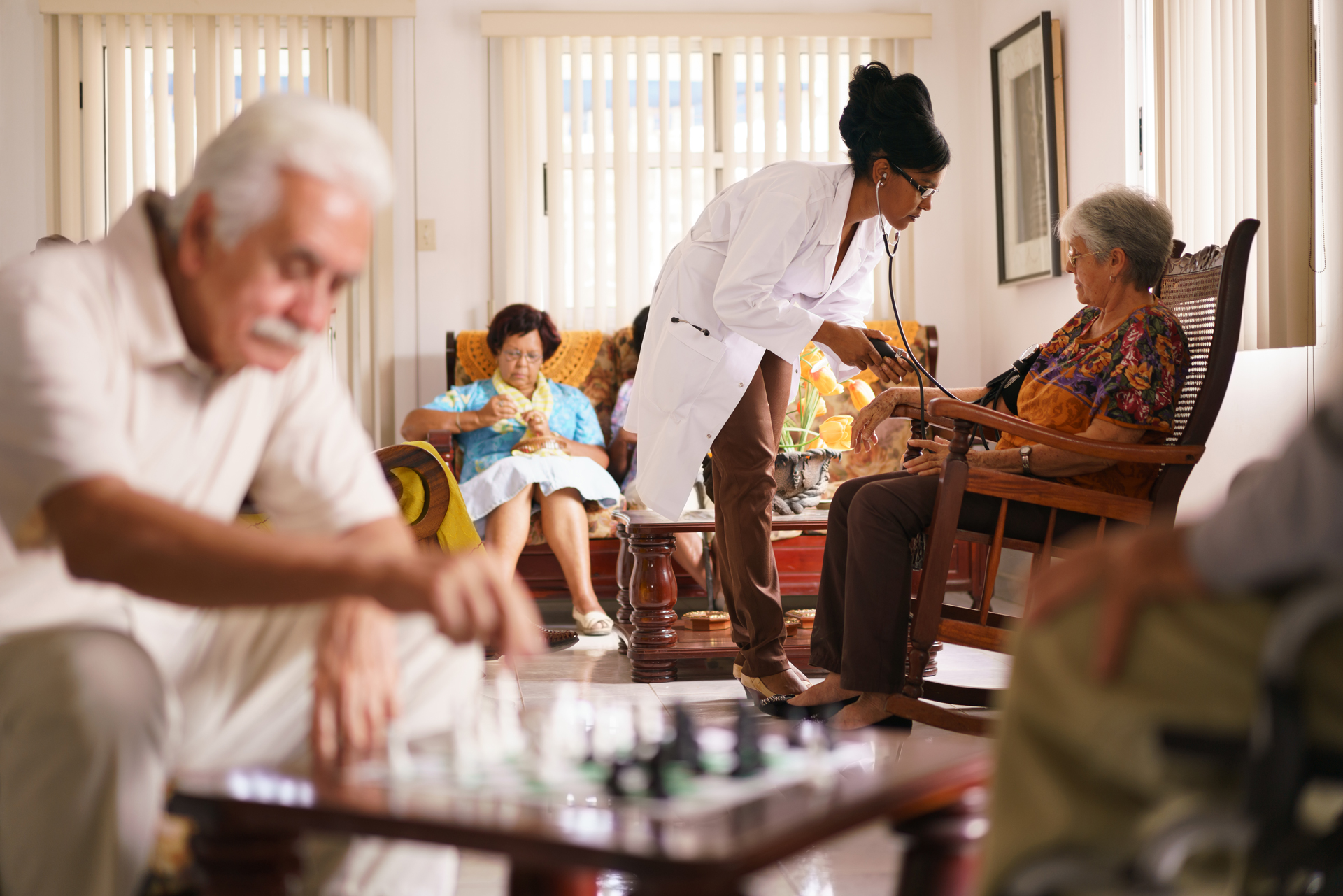 People sitting together within a community gathering in a senior living home.